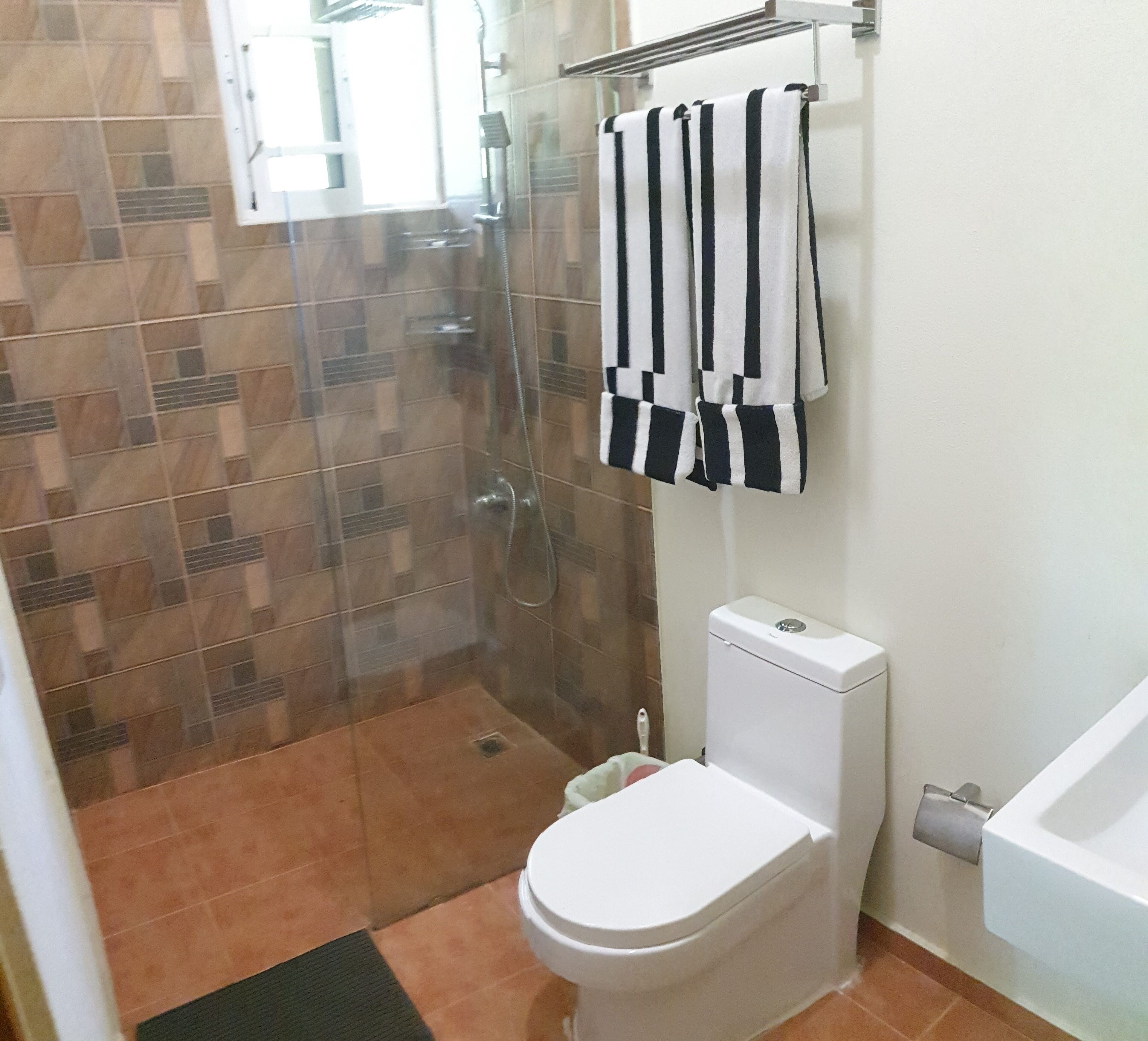 A bathroom with a glass-enclosed shower, a toilet, and a bathtub.