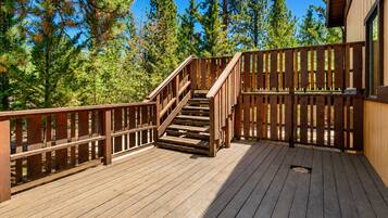 A wooden deck with a staircase leading to a building.