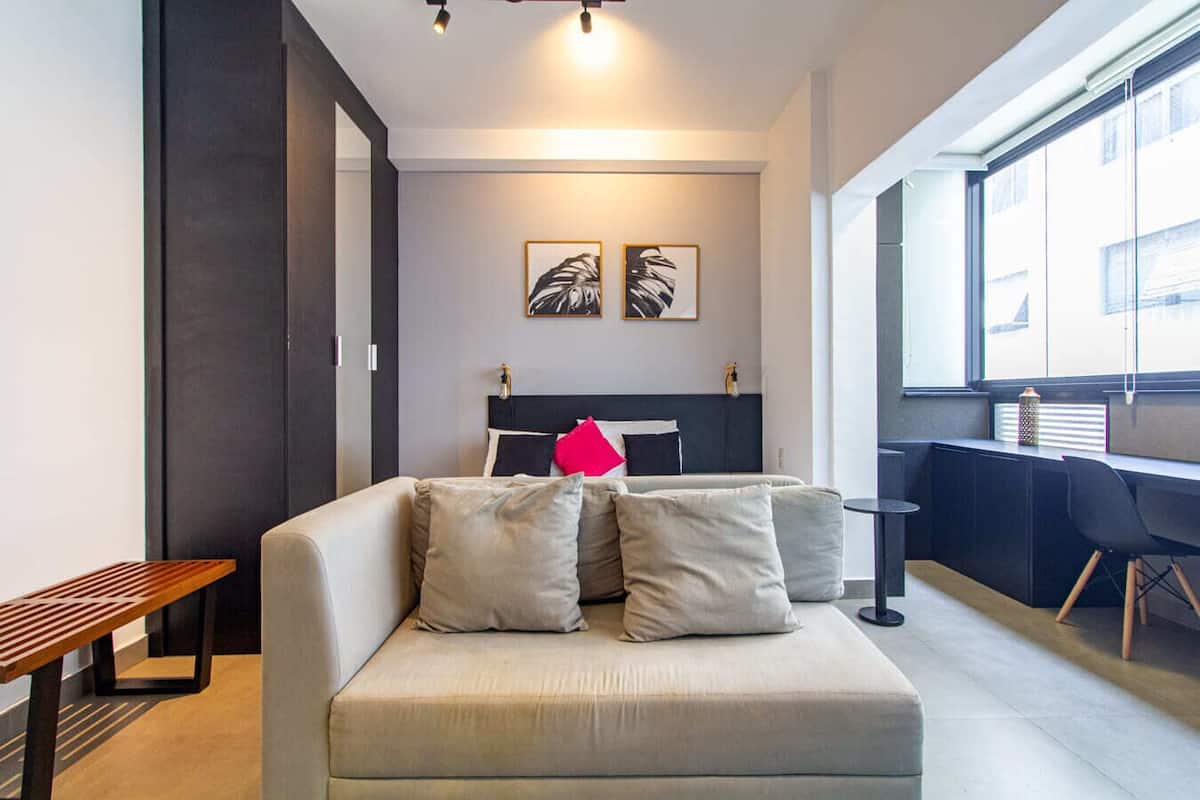 Una sala de estar moderna con un sofá, una mesita y una ventana con vistas.