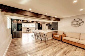 Relax in this open-plan living space with a kitchen area, sofa, and dining area with bar stools.