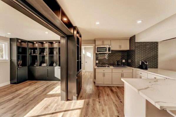 Enjoy cooking in this well-equipped kitchen with a stainless steel refrigerator, microwave, and coffee machine.