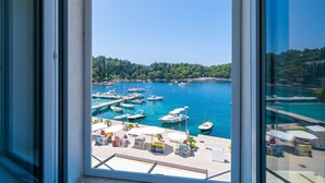 A marina with boats docked, a clear sky, and a view of the coastline. - Apartments Villa Royale - Deluxe One Bedroom Apartment with Sea View (Cavtat)