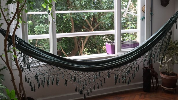 A hammock tied between two windows with a view of a lush garden. - Charming and peaceful Santa Teresa (Santa Teresa Rio de Janeiro)