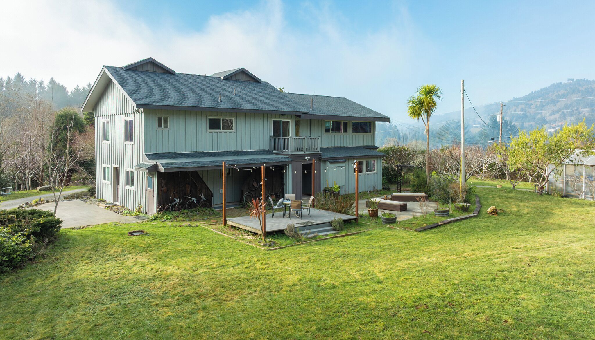A two-story house with a covered porch and a small deck.