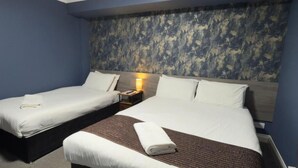 A hotel room with two beds, a nightstand, and a headboard with a textured design. - Terrace Lodge (Yeovil)