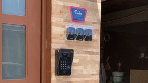 Eine Tür mit einem Zahlencode-Schloss und einem Schild mit der Aufschrift 'Timbre Solo Delivery'.