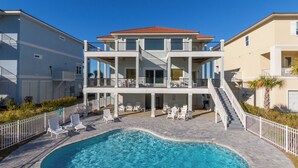 Un bâtiment à deux étages doté d’une piscine, d’un espace extérieur aménagé et d’un escalier menant à l’étage supérieur.