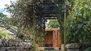 Una estructura de madera con un muro de piedra y un letrero que dice "Greystones Garden".