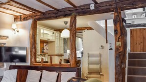 Una sala de estar acogedora con un banco de madera, un televisor y una escalera.