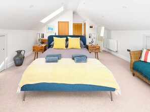 A bedroom with a large bed, bedside tables, a lamp, a radiator, and a view of the sky through a skylight. - Sunset Beach - UK42994 (Mortehoe, near Woolacombe)