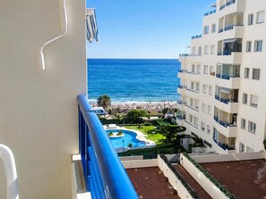 A balcony with a view of a beach and a swimming pool. - Coqueto apartamento con vistas 106 (marbella)