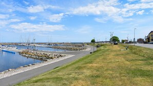 A marina with boats docked, a grassy area with a bench, and a clear sky. - Nice apartment in Simrishamn with WiFi (Simrishamn)