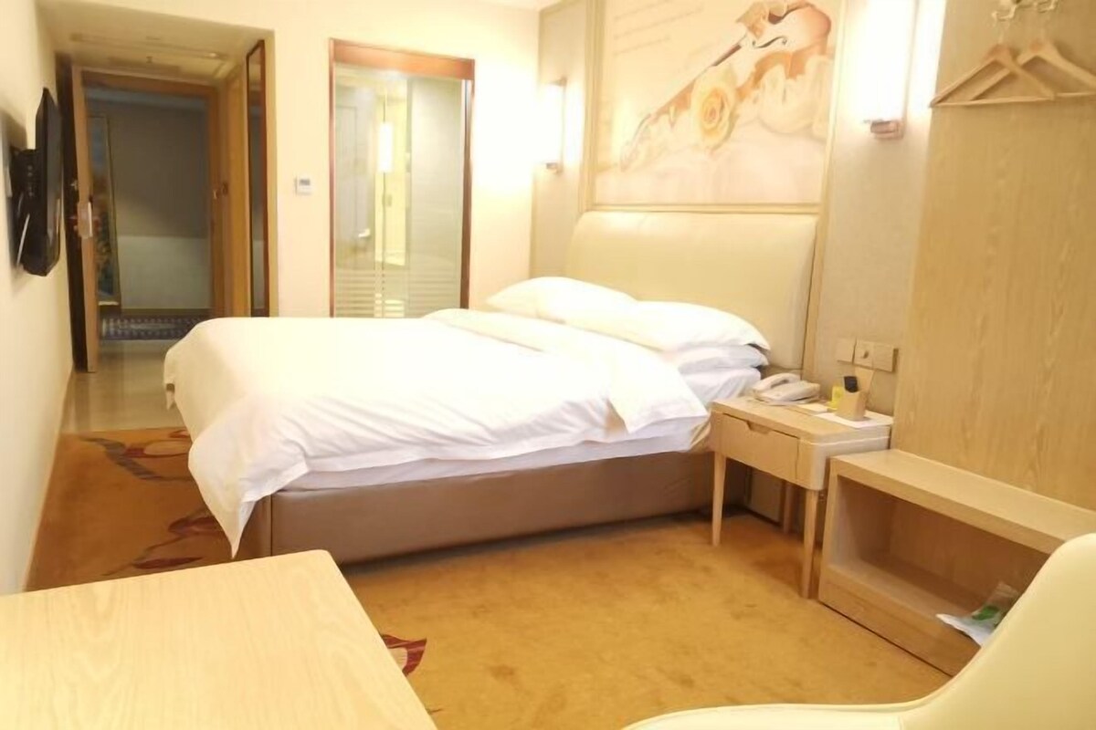 Una habitación de hotel con cama, mesita de noche y una silla.