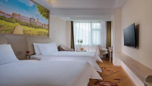 A hotel room with two beds, a desk, a chair, a TV, and a painting on the wall. - Vienna Hotel Chengdu Dufu Cottage The Jinsha Site (Chengdu)