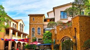 A courtyard with a traditional building, a covered seating area, and a golf cart.
