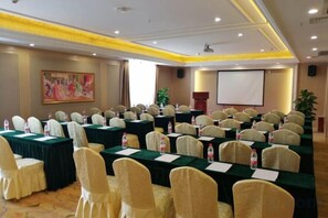 A conference room with rows of tables, chairs, and a projector screen. - Vienna Hotel (Chengdou Dufu Thatched Cottage Jinsha Site) (Chengdu)