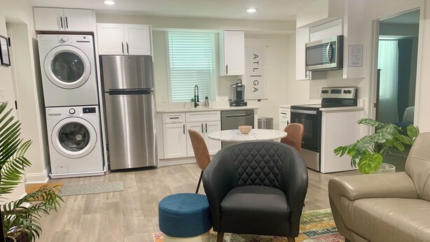 A compact kitchen with a washing machine, refrigerator, microwave, and a dining area with a round table and chairs. - FIFA World Cup - 4Mi to Stadium - Private Basement Apt - Free Parking - Kitchen (Atlanta)