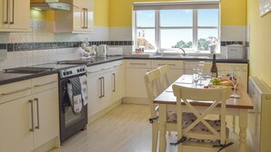Una cocina con comedor, un reloj en la pared y una ventana con vistas.