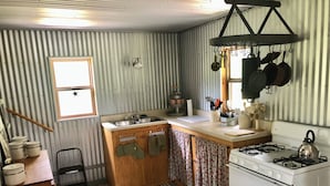 Une cuisine de taille réduite, équipée d’un évier, d’une cuisinière et d’une fenêtre.