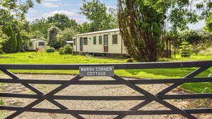 Un'area recintata con un cartello che riporta la scritta 'Marsh Corner Cottage'.