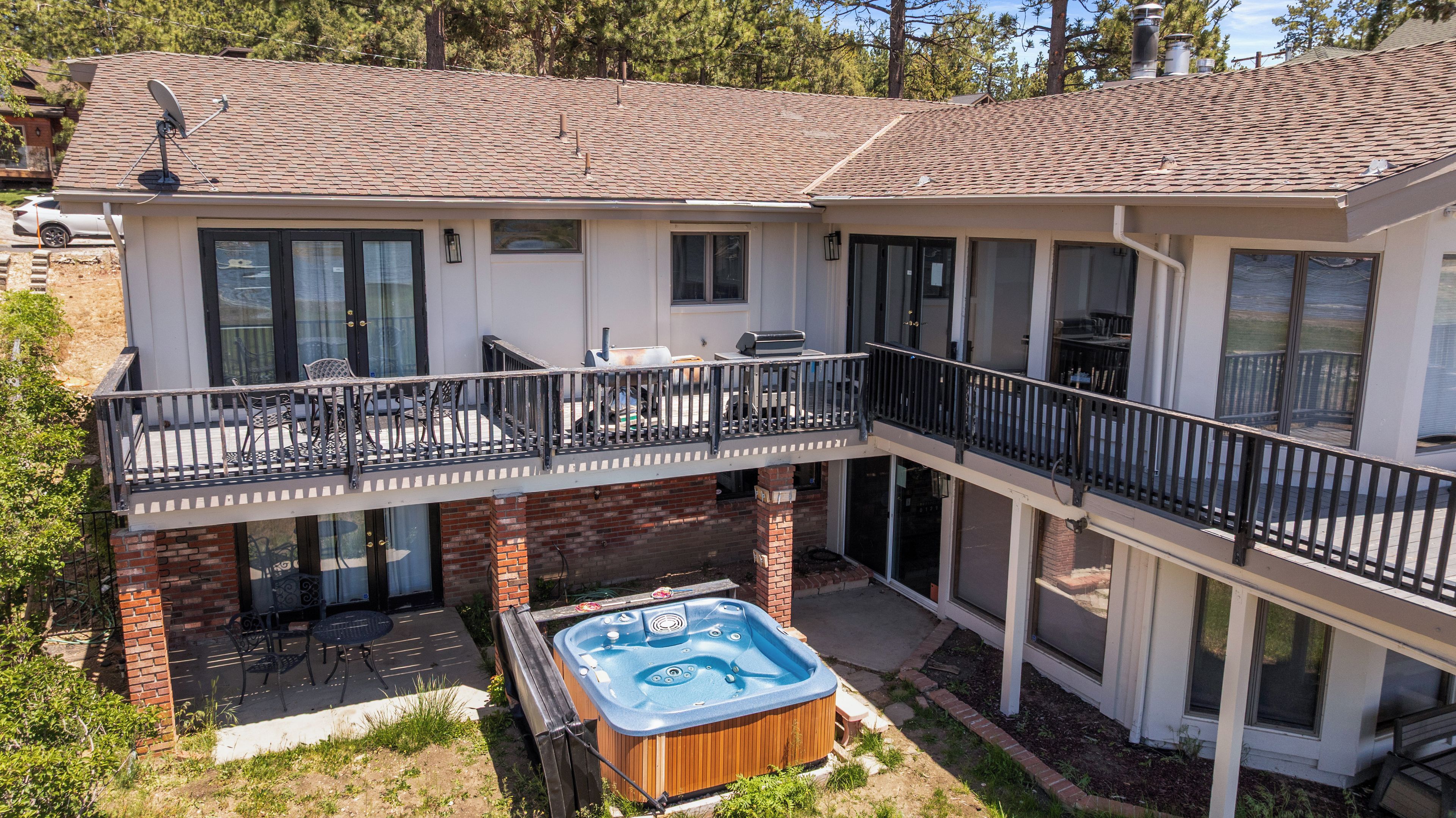 A two-story house with a balcony, a hot tub, and a satellite dish.