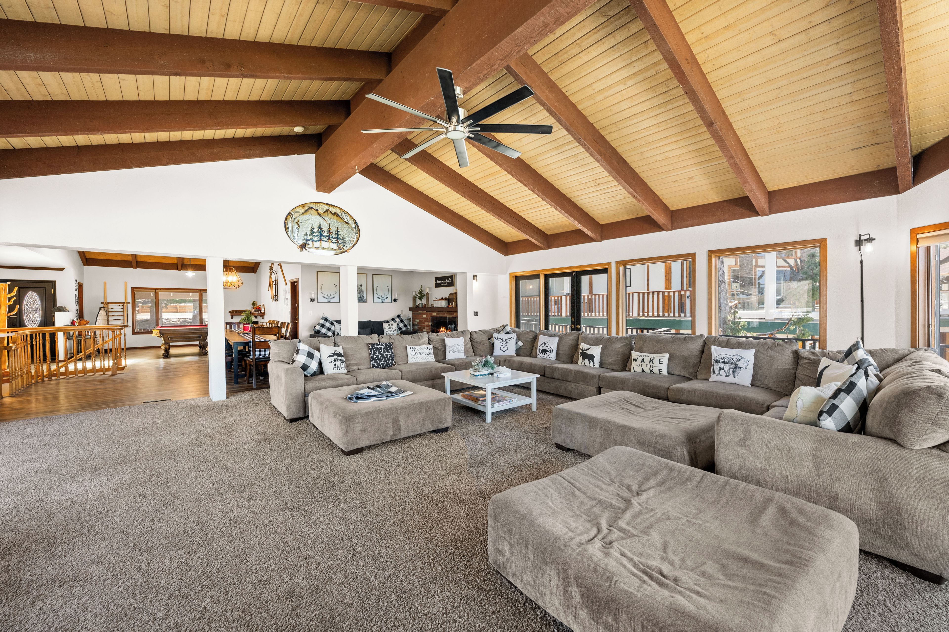 A spacious living room with a high ceiling, a large sofa set, and a dining area.
