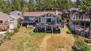 A two-story house with a balcony, a hot tub, and a fenced yard.