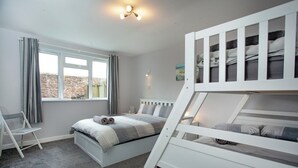 A bedroom with a bunk bed, a desk, and a chair. - Garden Apartment - UK44654 (Paignton)