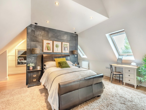 Une chambre avec un plafond de style industriel, un lit avec une tête de lit, un bureau avec une chaise et une fenêtre.