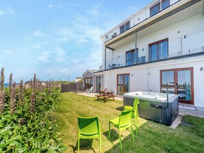 Ein modernes, zweistöckiges Haus mit Terrasse, Whirlpool und Meerblick.