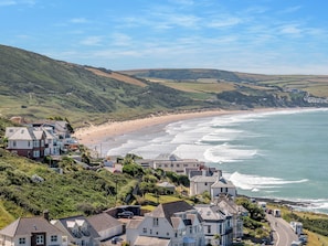 A coastal town with houses, a beach, and a view of the sea.