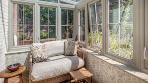 A sunroom with a sofa, a small table, and a chair. - The Old Reading Room (Salhouse, near Norwich)