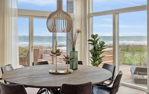 Enjoy meals in this ocean-view dining area with a round table and comfortable seating.