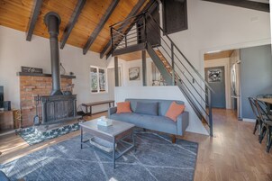 Una sala de estar moderna con chimenea, una escalera y un comedor.