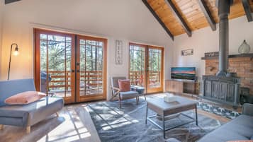 A spacious living room with a fireplace, large windows, and a cozy seating area.