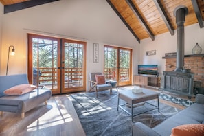 Un salón amplio con chimenea, ventanas grandes y una zona de estar acogedora.