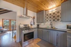 Una cocina moderna con una estufa grande, armarios grises y un salpicadero con estampado de estrellas.