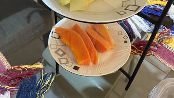 Una mesa con un plato de fruta cortada y un plato de rodajas de naranja.
