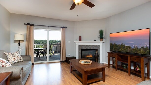 A living room with a fireplace, a television, and a view of the outdoors. - OverlookingCityLightsPigeonForge (Pigeon Forge)