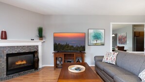A living room with a fireplace, a television, and a sofa. - OverlookingCityLightsPigeonForge (Pigeon Forge)