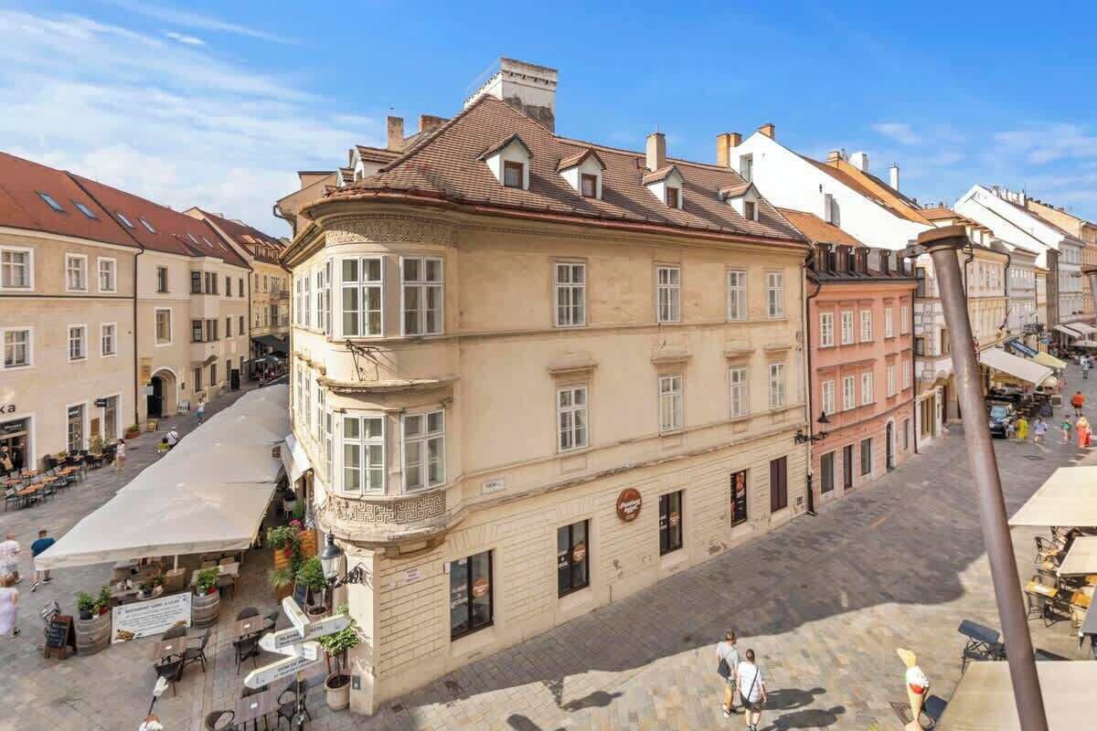 En historisk bygning med en indgang i hjørnet, store vinduer og en murstensfacade.