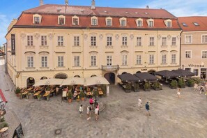 A historic building with a courtyard, outdoor seating, and a sign for 'Vinimka'. - Exclusive Apartment in Centre (Bratislava)