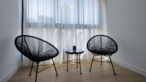 A room with two black wireframe chairs and a small round table with a potted plant. - DOS CALAS sunny apartment (Benidorm)