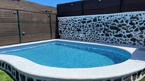 A swimming pool with a stone wall and a fenced area. - Vistamar La Caleta 2 (La Caleta)