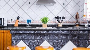 A kitchen with a marble countertop, a microwave, a knife block, a plant, and a sink. - Vistamar La Caleta 2 (La Caleta)