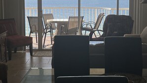 Une chambre avec vue sur l’océan, dotée d’un balcon avec des chaises et une table.