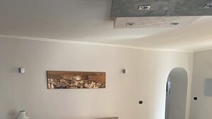 Ein Wohnzimmer mit einer Couch, einem Esstisch mit einer Schüssel und einer Lampe.