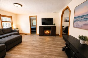 A living room with a fireplace, a television, and a sofa.