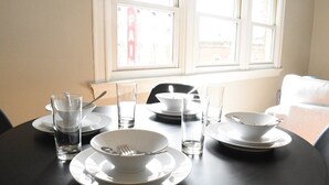 Una mesa de comedor dispuesta con platos, tazones, vasos y cubiertos.