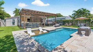 A modern house with a swimming pool, outdoor seating, and a pergola. - Luxury Private Resort-Style Retreat in the Heart of Fort Lauderdale (Fort Lauderdale)